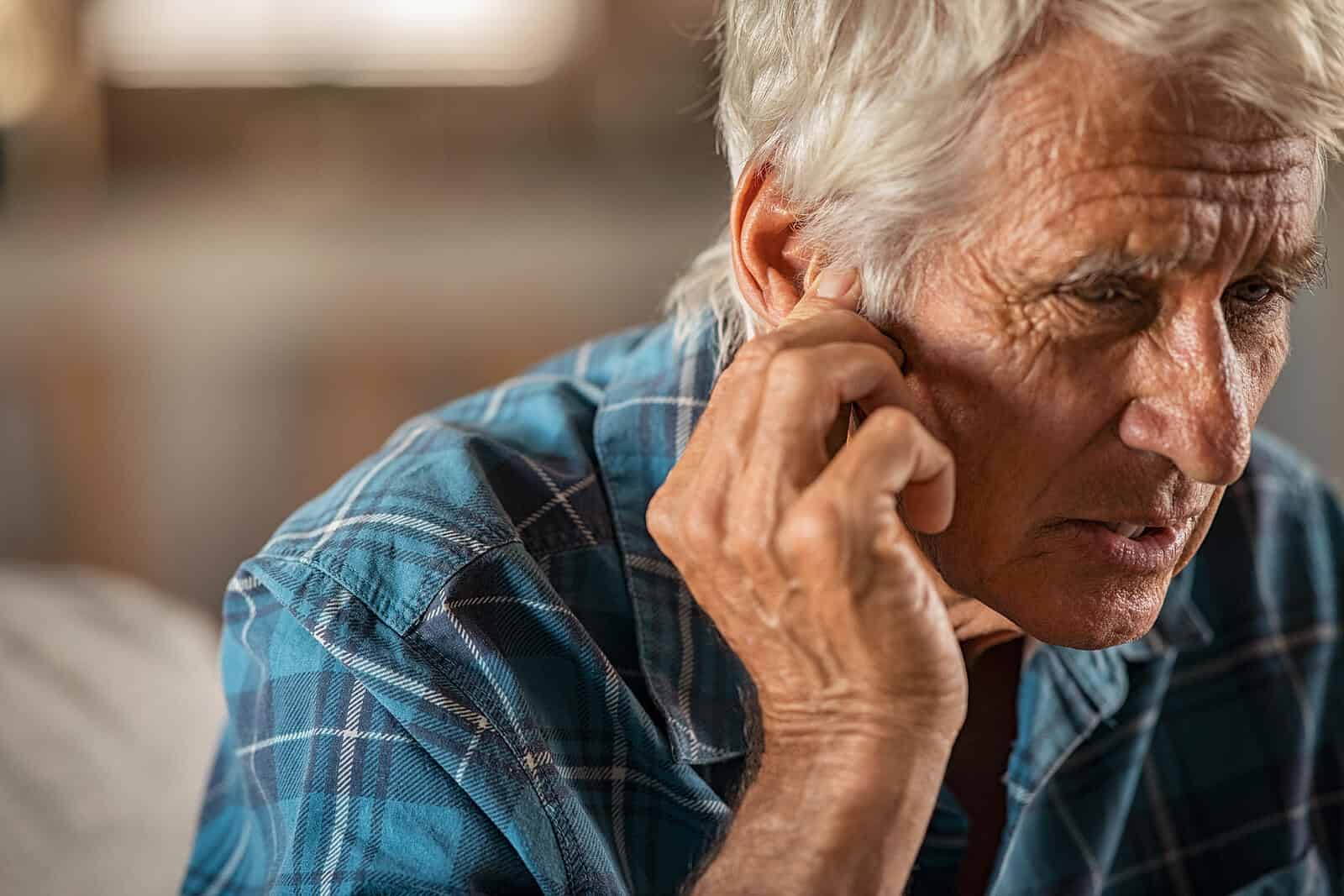 Senior man holding ears in pain