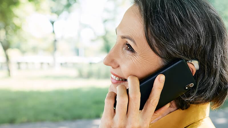 woman with hearing aid on the phone